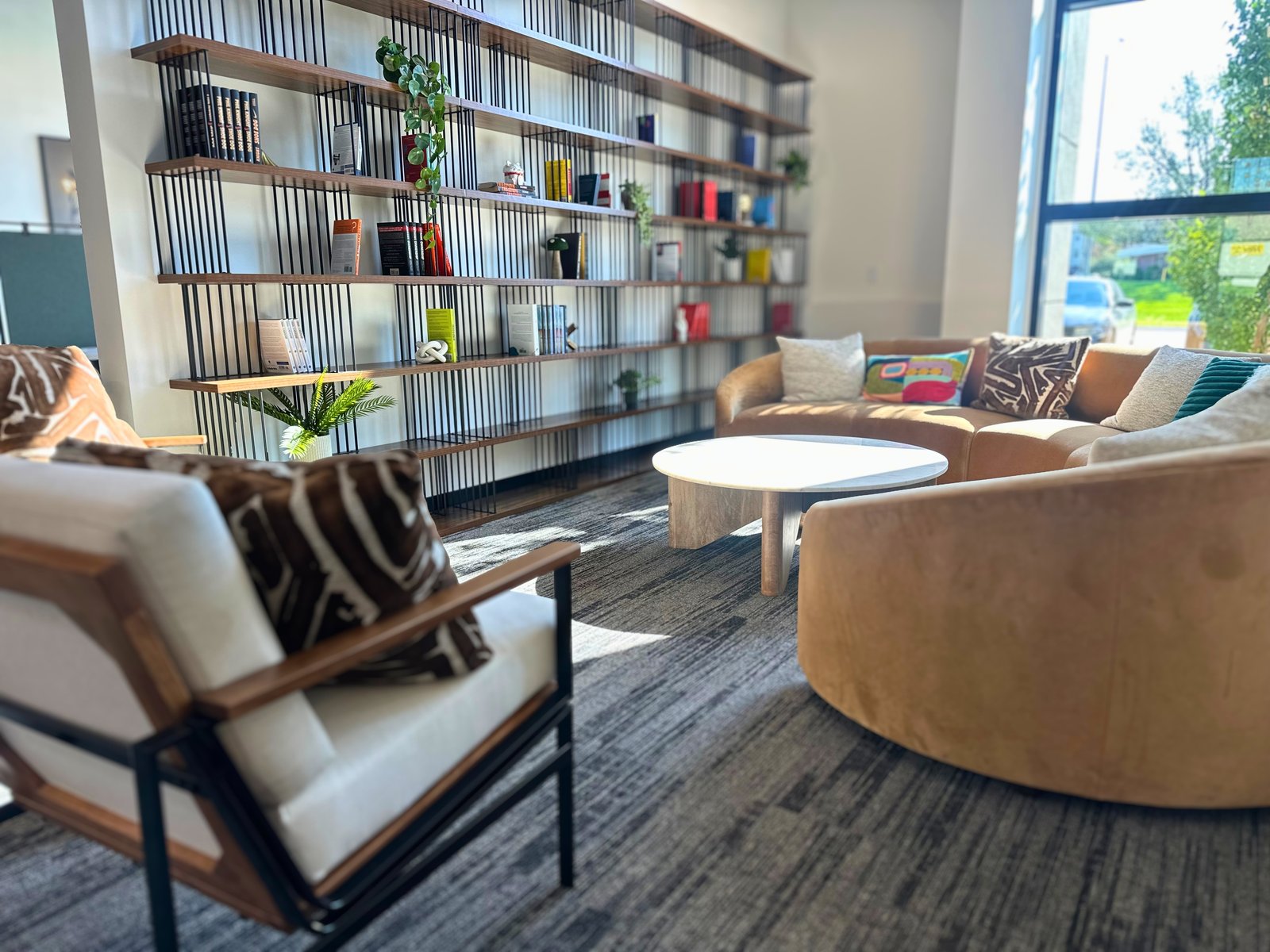 Lounge with bookshelf wall and curved sofa at SpringPad in Lincoln, Nebraska