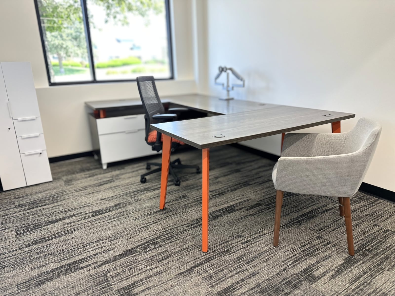 Furnished private window office with a full executive desk and guest chair at SpringPad in Lincoln, Nebraska