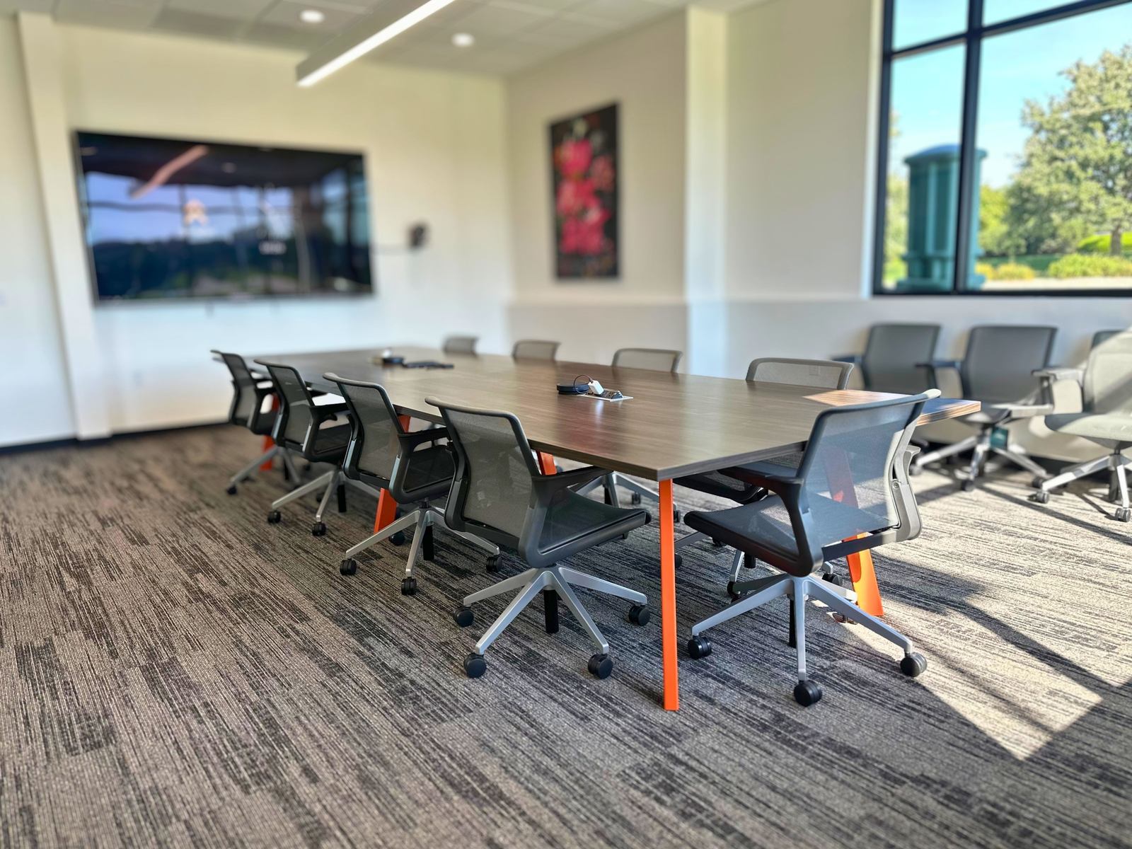Conference room with large display and orange accent table at SpringPad in Lincoln, Nebraska