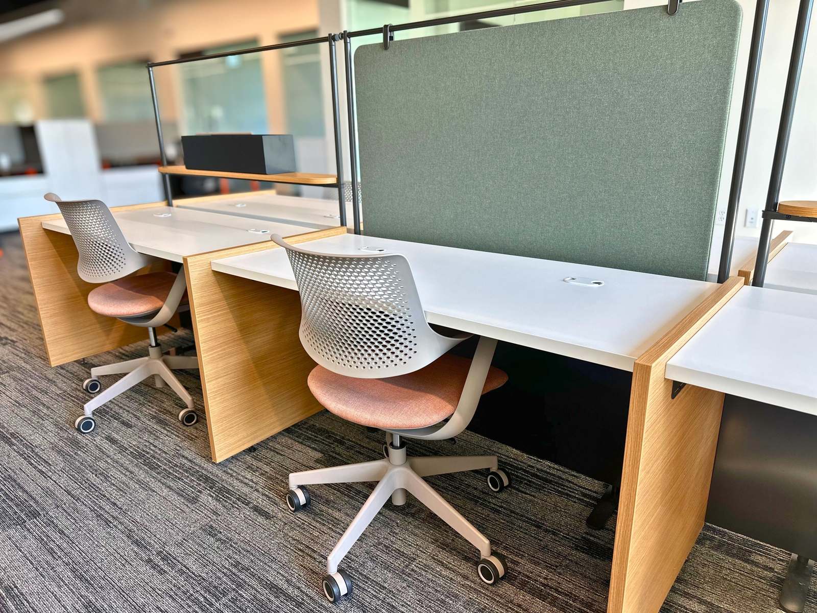 Open hoteling desks with green acoustic dividers at SpringPad in Lincoln, Nebraska